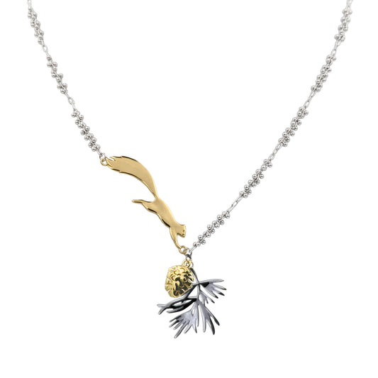 A close-up view of the Zoobotanic Squirrel and Pine Forest Z06-A yellow and white gold-toned necklace. Where designs call nature to mind, it features a yellow gold-toned jumping squirrel attached to a ball-clustered chain holding a pinecone and pine leaf pendant.